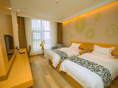 a hotel room with two beds and a flat screen tv at GreenTree Inn Tongchuan Yaozhou District New District Hospital Business Hotel in Yaozhou