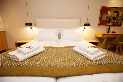 a bed with two white towels on top of it at No21 Luxury Suites in Thessaloniki