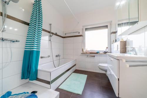 La salle de bains est pourvue d'une baignoire, de toilettes et d'un lavabo. dans l'établissement Private House, à Hanovre