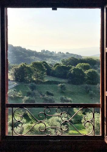 a window with a view of a green field at Borgo San Gusmè in San Gusmè