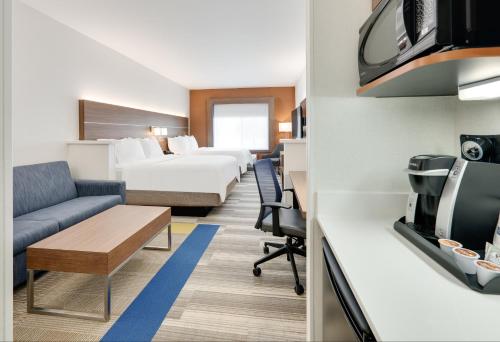 a hotel room with two beds and a couch at Holiday Inn Express & Suites Mitchell by IHG in Mitchell