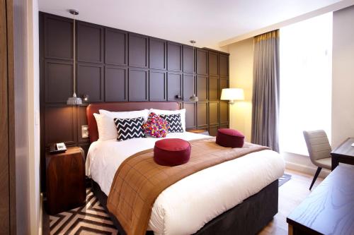 Hotel Indigo York, an IHG Hotel في يورك: غرفة نوم بسرير كبير مع اللوح الأمامي كبير