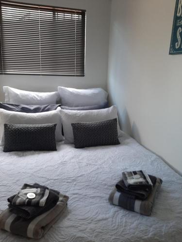 a bedroom with two towels on a bed at Vogel's Nest in George