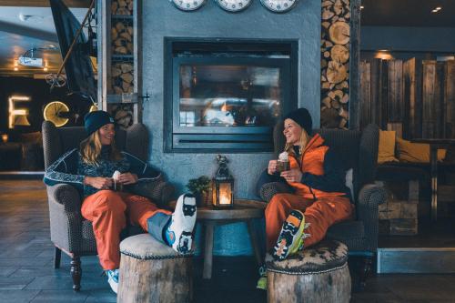two people sitting in chairs in a room at Hemsedal Cafe Skiers Lodge in Hemsedal