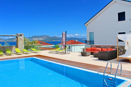 a villa with a swimming pool and a patio at Apartments Kula in Janjina
