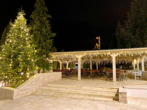 a christmas tree in front of a gazebo at Hotel Sunny Hill in Cluj-Napoca