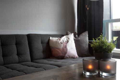 a couch with pillows and a table with candles at Hemsedal Cafe Skiers Lodge in Hemsedal