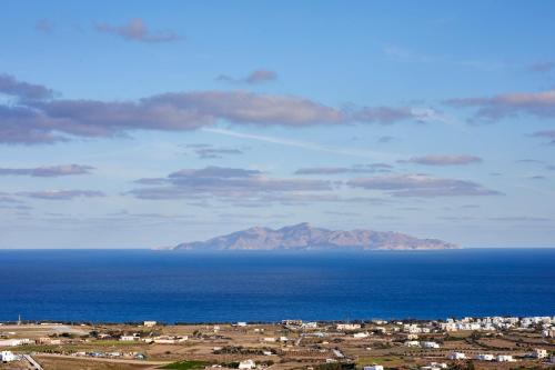 a view of the ocean with a mountain in the distance at Nano Suites in Éxo Goniá