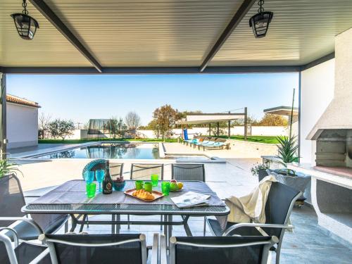 un patio con mesa y sillas y una piscina en Beautiful Villa in Vrsar with Swimming Pool en Vrsar