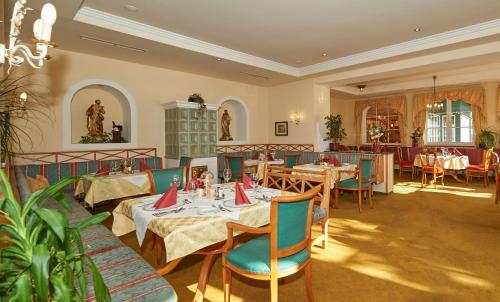 a restaurant with tables and chairs in a room at Wohlfühlresort und Feriengut Martinerhof in Sankt Martin am Tennengebirge