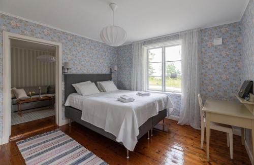 a bedroom with a bed and a desk and a window at Strandvillan Ljugarn in Ljugarn