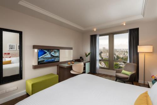 Habitación de hotel con cama y escritorio en Leonardo City Tower Hotel Tel Aviv, en Tel Aviv