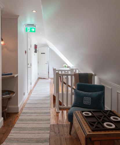 a stairway with a green exit sign and a chair at Strandvillan Ljugarn in Ljugarn