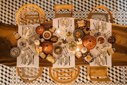 une table avec des assiettes de nourriture au-dessus dans l'établissement Riad Le Pèlerin, à Marrakech