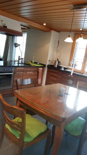 a kitchen with a wooden table and some chairs at Chalet Bärgblick in Grindelwald
