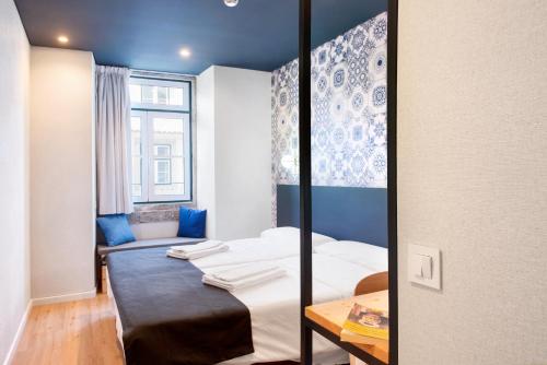 a small room with a bed and a table at The Central House Lisbon Baixa in Lisbon