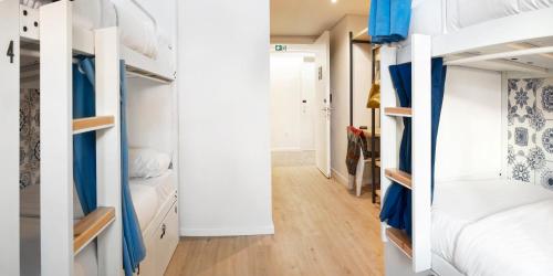 a room with white bunk beds and a hallway at The Central House Lisbon Baixa in Lisbon