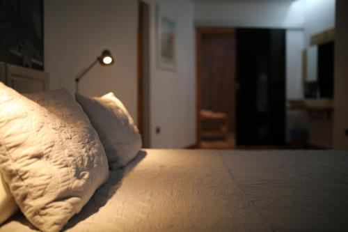 a bed with a pillow and a lamp on it at Las Coles Apartasuites in Xàtiva