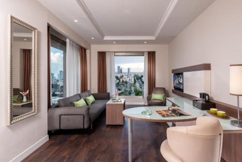 
a living room filled with furniture and a kitchen at Leonardo City Tower Hotel Tel Aviv in Tel Aviv
