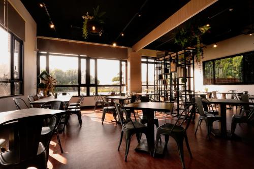 ein Restaurant mit Tischen und Stühlen und großen Fenstern in der Unterkunft Ouxiang Manor Hotel in Yuanlin