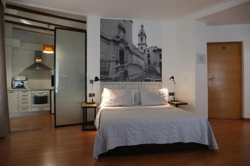 a bedroom with a bed with a black and white picture on the wall at Las Coles Apartasuites in Xàtiva