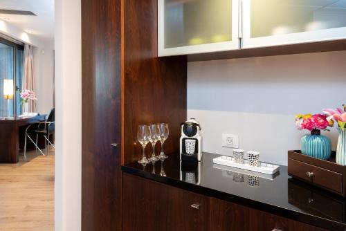 a kitchen with wine glasses on a wall at Leonardo City Tower Hotel Tel Aviv in Tel Aviv