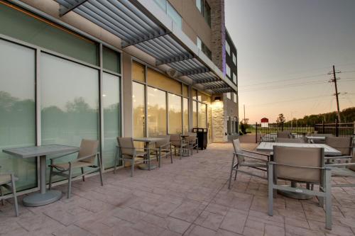 a patio with tables and chairs outside of a building at Holiday Inn Express & Suites - Mount Vernon by IHG in Mount Vernon