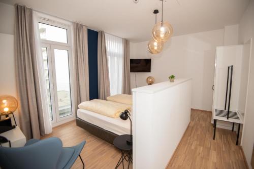 a small bedroom with a bed and a window at Design Hotel Sophie´s in Norderney