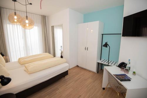 a bedroom with a bed and a desk in it at Design Hotel Sophie´s in Norderney