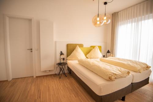a bedroom with a large bed and a chandelier at Design Hotel Sophie´s in Norderney