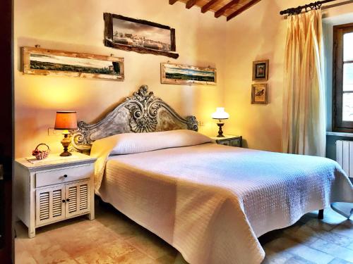 a bedroom with a large bed with a white bedspread at Borgo San Gusmè in San Gusmè