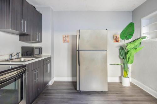 a kitchen with a stainless steel refrigerator and a plant at Philly Coed Dorm!! 15 Min Train to Center City!! in Philadelphia