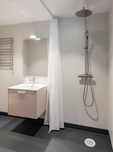 a bathroom with a sink and a shower curtain at Strandvillan Ljugarn in Ljugarn