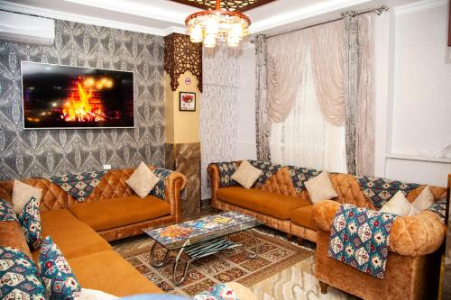 a living room with couches and a fire on the wall at Mildom Hotel Baku in Baku