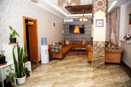 a living room with a couch and a fireplace at Mildom Hotel Baku in Baku