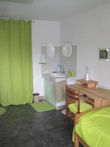 - une chambre avec un rideau vert et un lavabo dans l'établissement Maison Saint Louis, à Paray-le-Monial