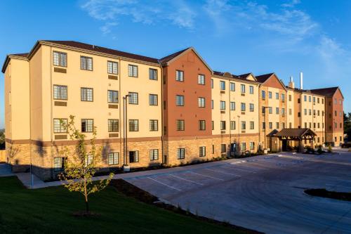 a large brick building with a parking lot at Staybridge Suites Omaha West by IHG in Omaha