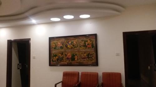 a painting on the wall of a room with orange chairs at Hotel Dream World Boarding & Lodging in Sivaganga
