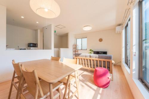 a kitchen and dining room with a wooden table and chairs at Riverside Yofuke AFP Villa in Nago