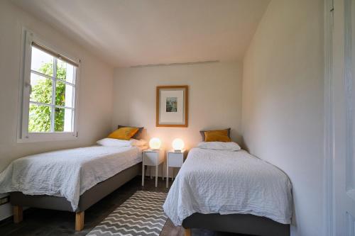 two beds in a small room with two windows at Ferienwohnung im Fachwerkhof 'Haus in Bewegung' in Seelscheid