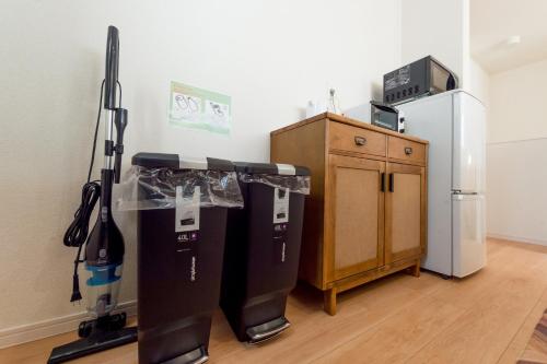 a room with two vacuum cleaners and a refrigerator at Riverside Yofuke AFP Villa in Nago
