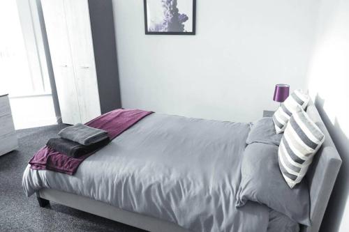 a bedroom with a bed with pillows on it at Outstanding and Spacious modern 4 bedroom house in Hull