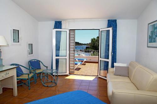 a living room with a couch and a table and chairs at Hotel Calina in Cadaqués