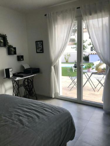 une chambre avec un lit et une porte coulissante en verre dans l'établissement jardin zen, à La Londe-les-Maures