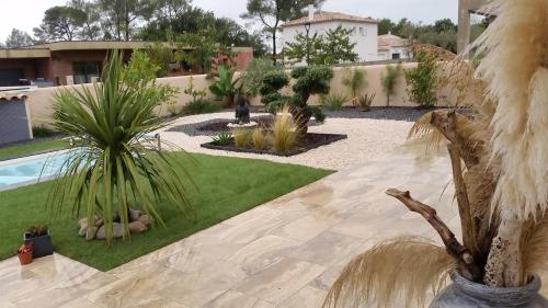 un jardín con palmeras y una piscina en jardin zen, en La Londe-les-Maures
