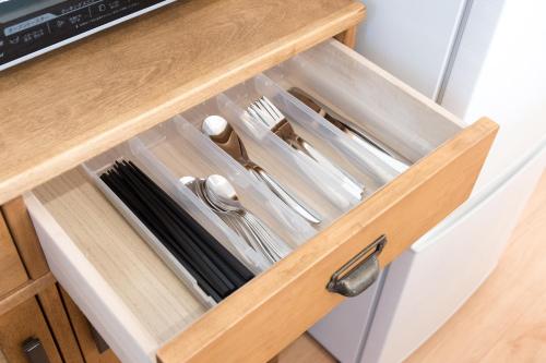 a drawer in a kitchen cabinet with utensils at Riverside Yofuke AFP Villa in Nago