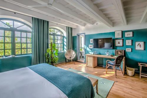 een slaapkamer met blauwe muren en een bed en een bureau bij Santa Ponsa Fontenille Menorca in Alaior