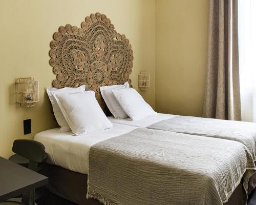a bedroom with two beds with a large headboard at New Hotel Le Quai - Vieux Port in Marseille