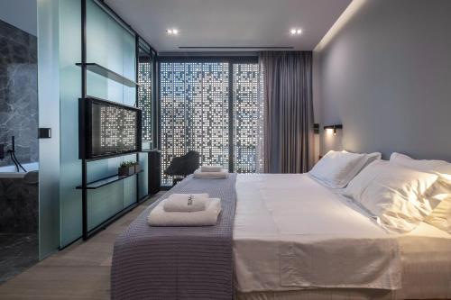 a bedroom with a large bed and a large window at The Duke Boutique Suites in Athens