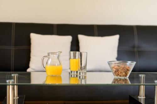 a table with two glasses of orange juice on it at Moonlight Apartments & Suites in Fira